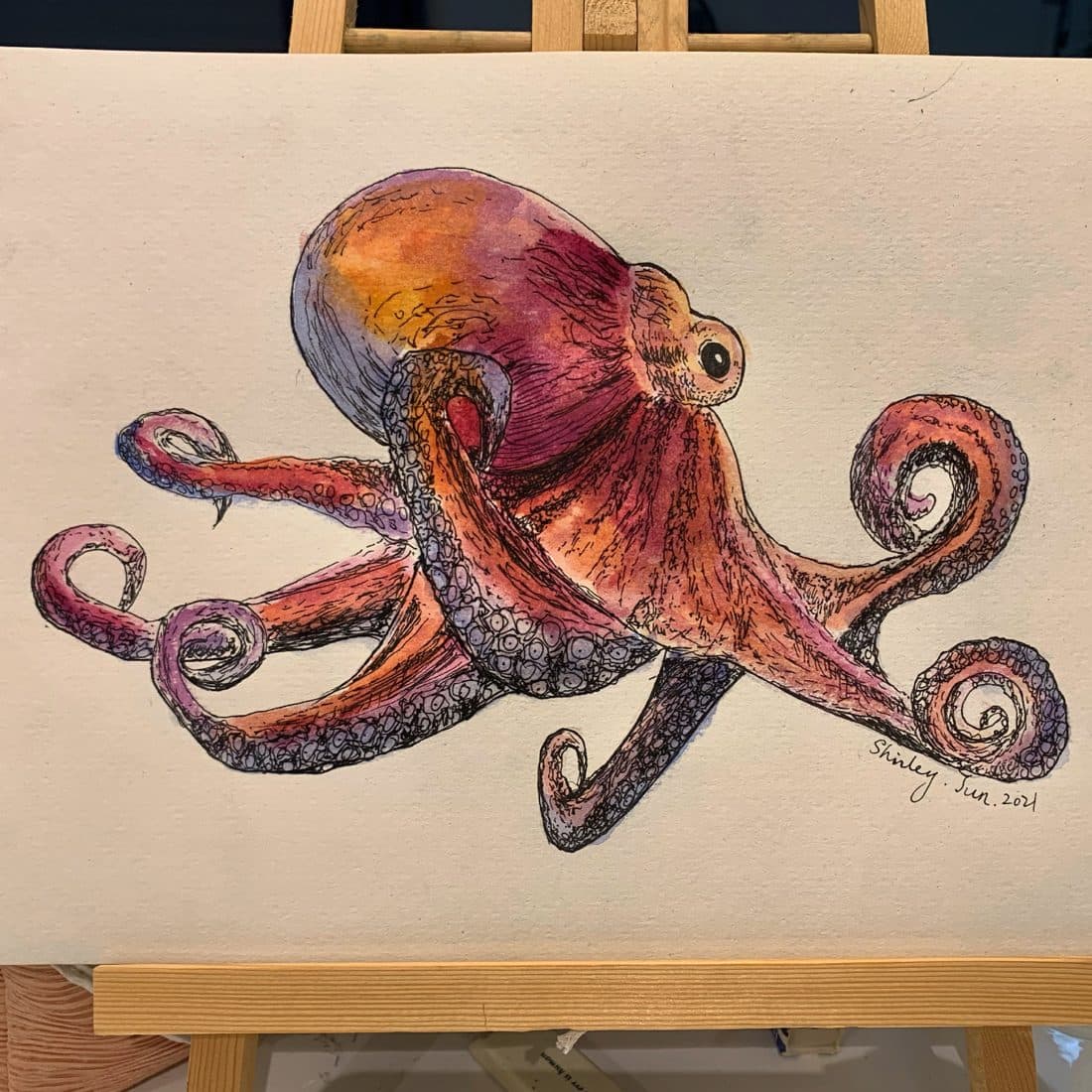 A watercolor octopus on an easel — painted and signed by Shirley, 2021